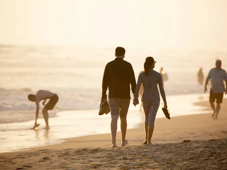 A couple walking hand in hand along a beach